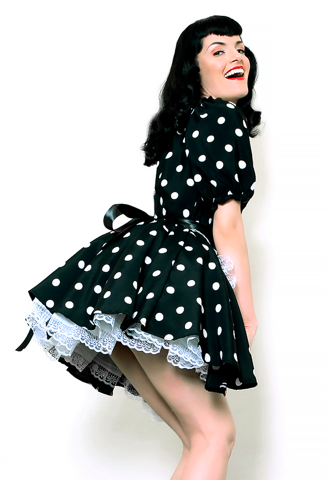 Bernie Dexter in original Versatile Fashions Elastic Maid Dress in black & white polka dot w/ white lace trim apron back