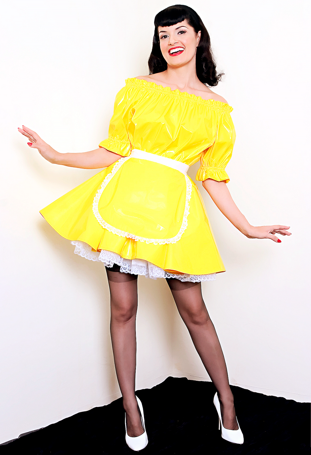 Bernie Dexter in original Versatile Fashions Elastic Maid Dress in yellow PVC w/ white lace trim apron